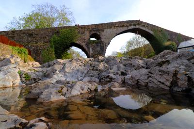 Reflejo del puente romado en el río Sella