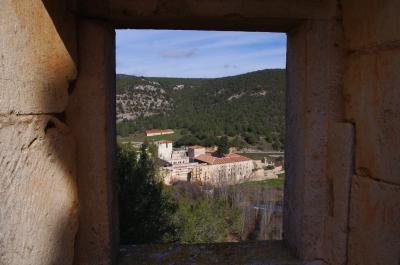 Cuadro del monasterio enmarcado por una ventana de la ermita